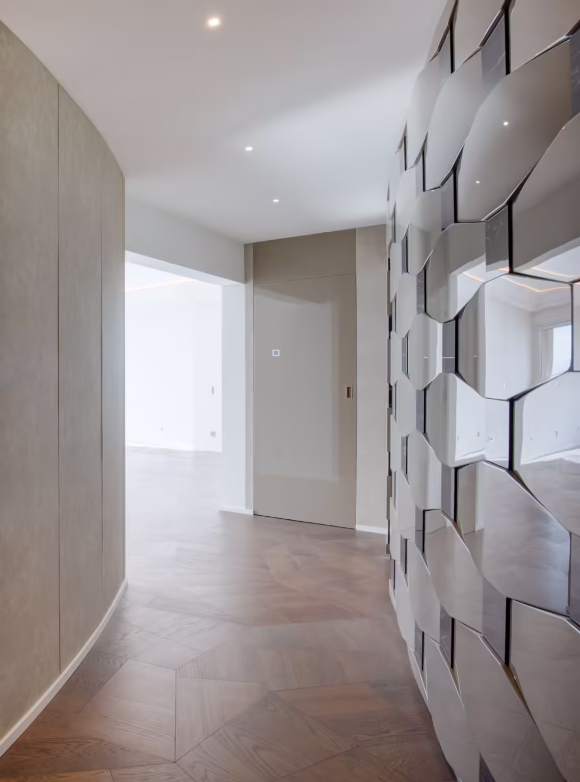 Corridoio dell'Annonciade alla consegna: parete curva rivestita, divisorio in pannelli sfaccettati, faretti a incasso e parquet scuro